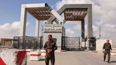 جندي فلسطيني يقف أمام بوابة معبر رفح الحدودية watanserb.com