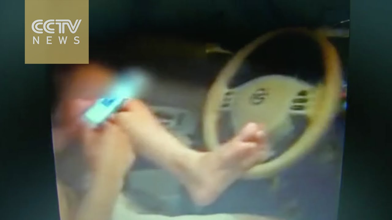 شبه عاري يقود سيارته بقدم واحد ويلعب على هاتفه!