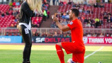 لحظة قيام لاعب كرة قدم بطلب الزواج من حبيبته على خط المنتصف لملعب كرة القدم قبيل بدء المباراة.