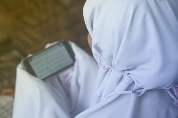 فتاة تقرأ القرآن عبر تطبيقات الجوال
