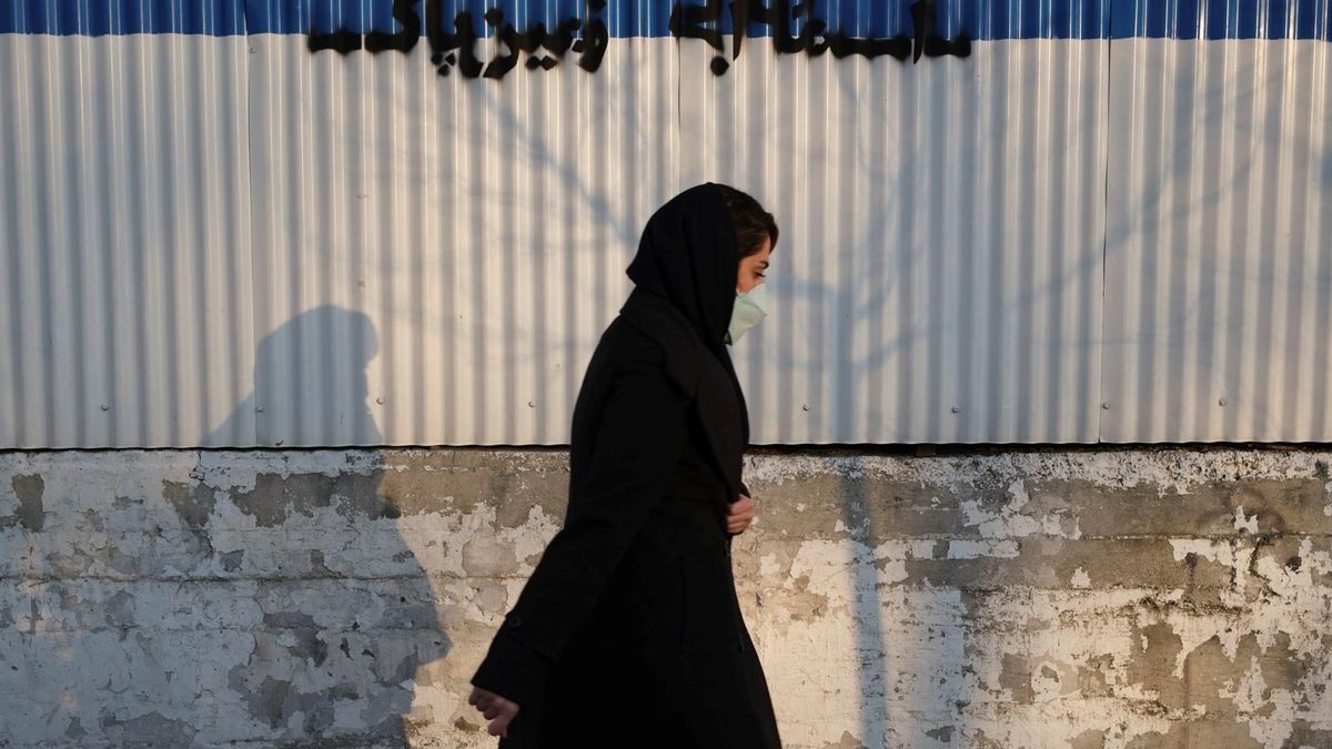 امرأة محجبة تمشي في أحد شوارع طهران watanserb.com