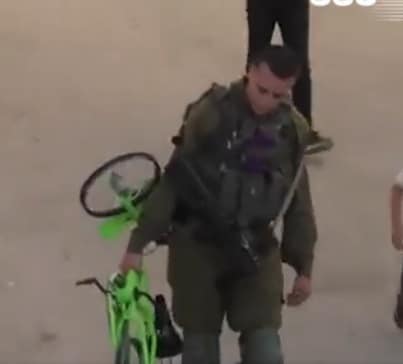جندي إسرائيلي يسرق دراجة طفل فلسطيني watanserb.com