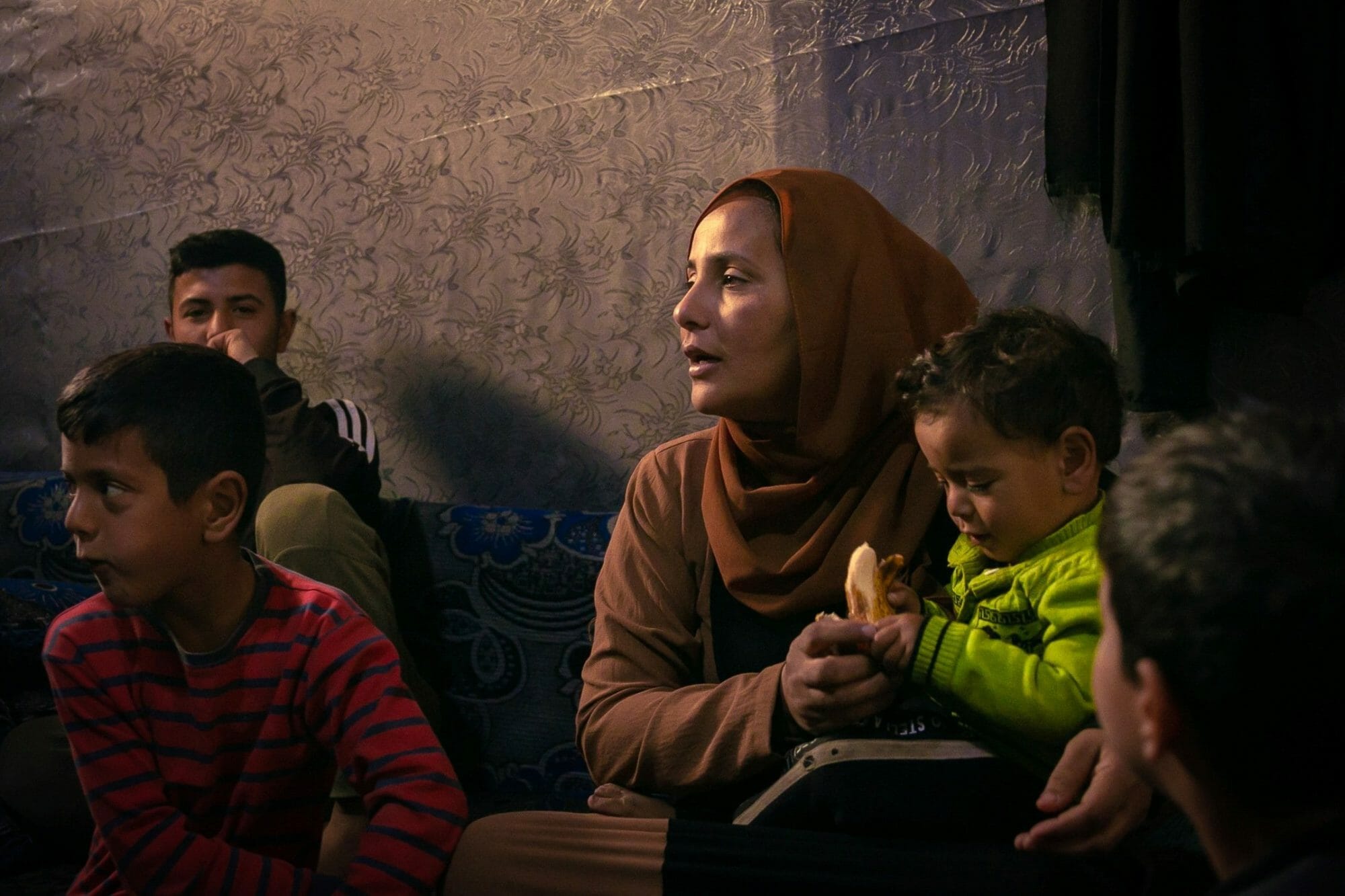 خولة حسن تجلس مع أطفالها داخل خيمة عائلتها في مخيم للاجئين بالقرب من بر الياس