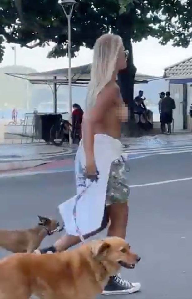 امرأة عارية الصدر تمشي مع كلابها 