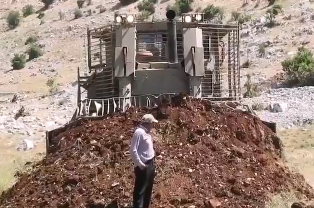 جرافة عسكرية إسرائيلية تقوم بردم مواطن لبناني بالتراب