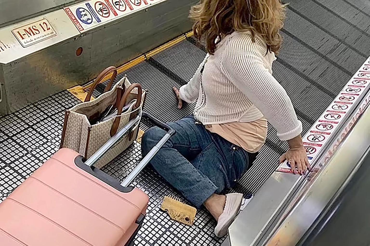 تعثرت المسافرة وسقطت بسبب حقيبتها الوردية
