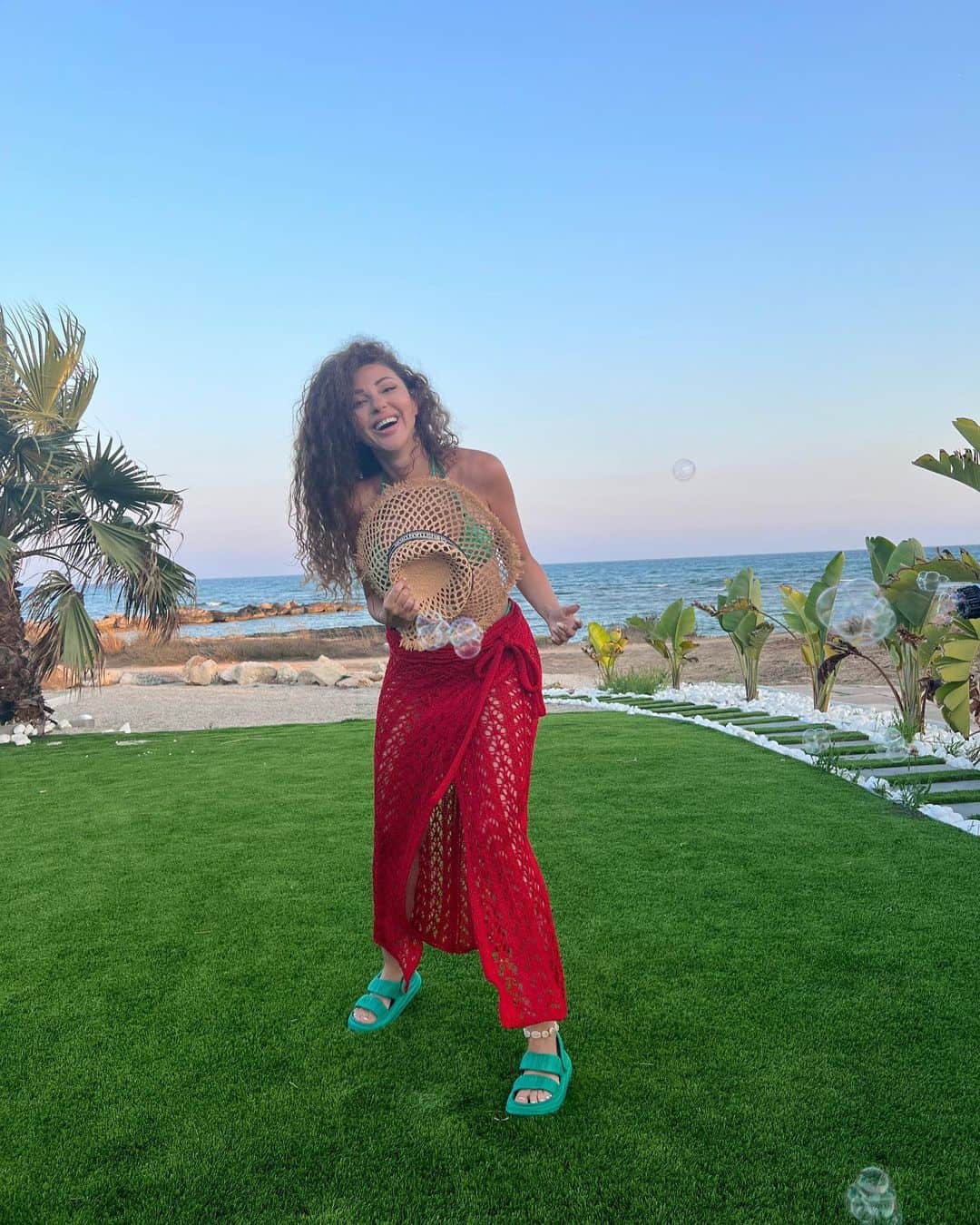 ظهرت مريام فارس موجهة جسدها ووجها نحو الكاميرا، مستعينة بقبعتة من القش المفرغ لتغطية صدرها