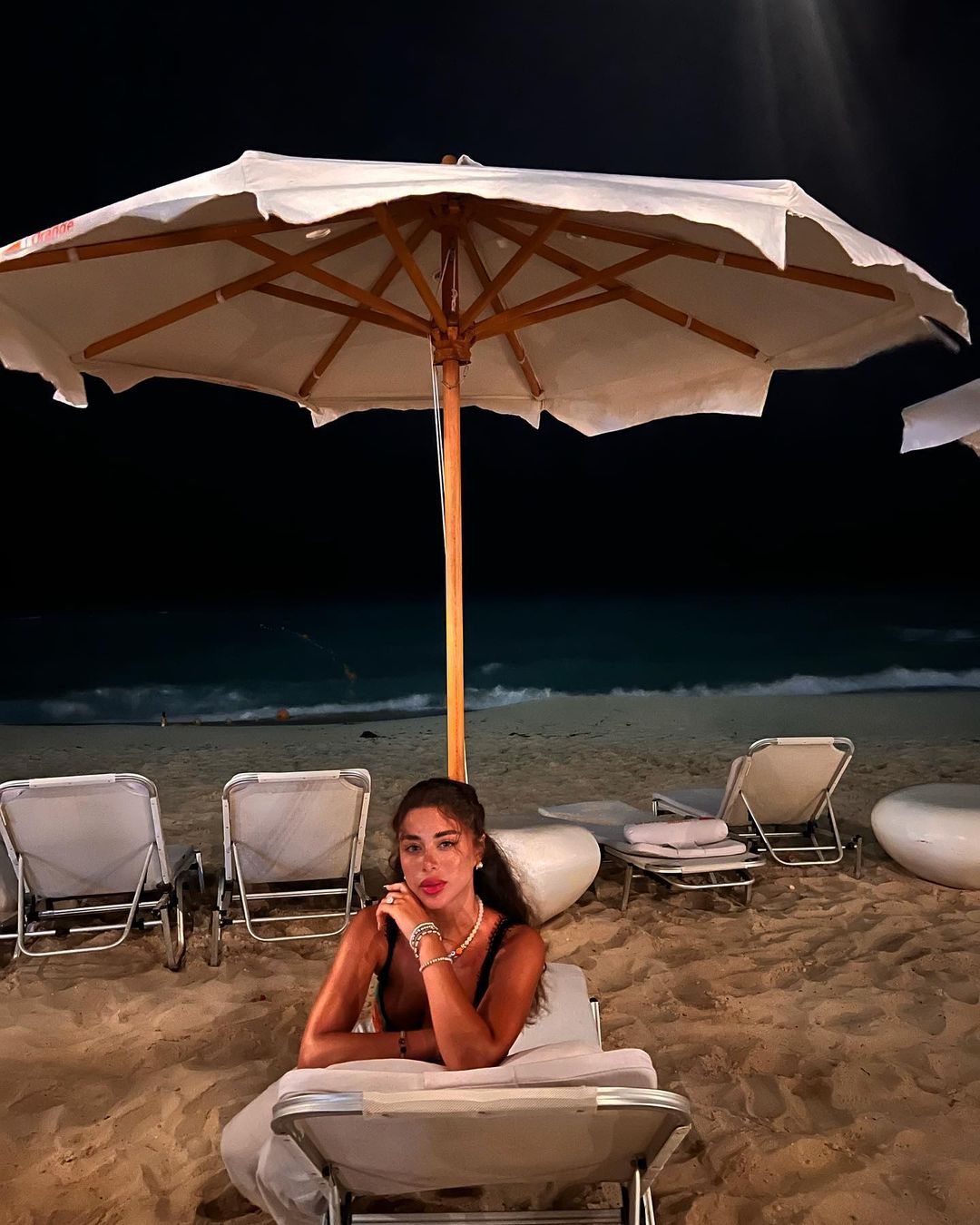 يارا السكري من على الشاطئ وهي تجلس على كرسي البحر بشكل عكسي متوجهة نحو الكاميرا