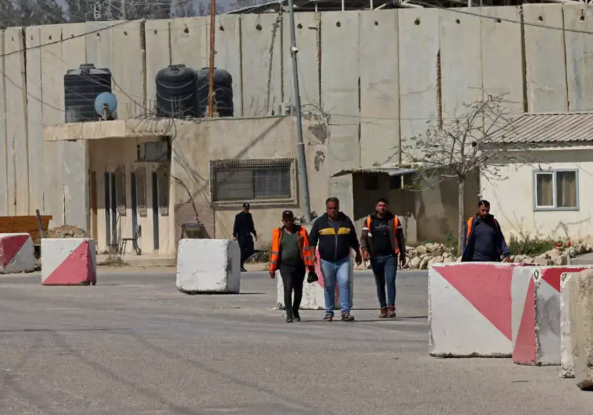 فلسطينيون يسيرون عند معبر كرم أبو سالم في رفح