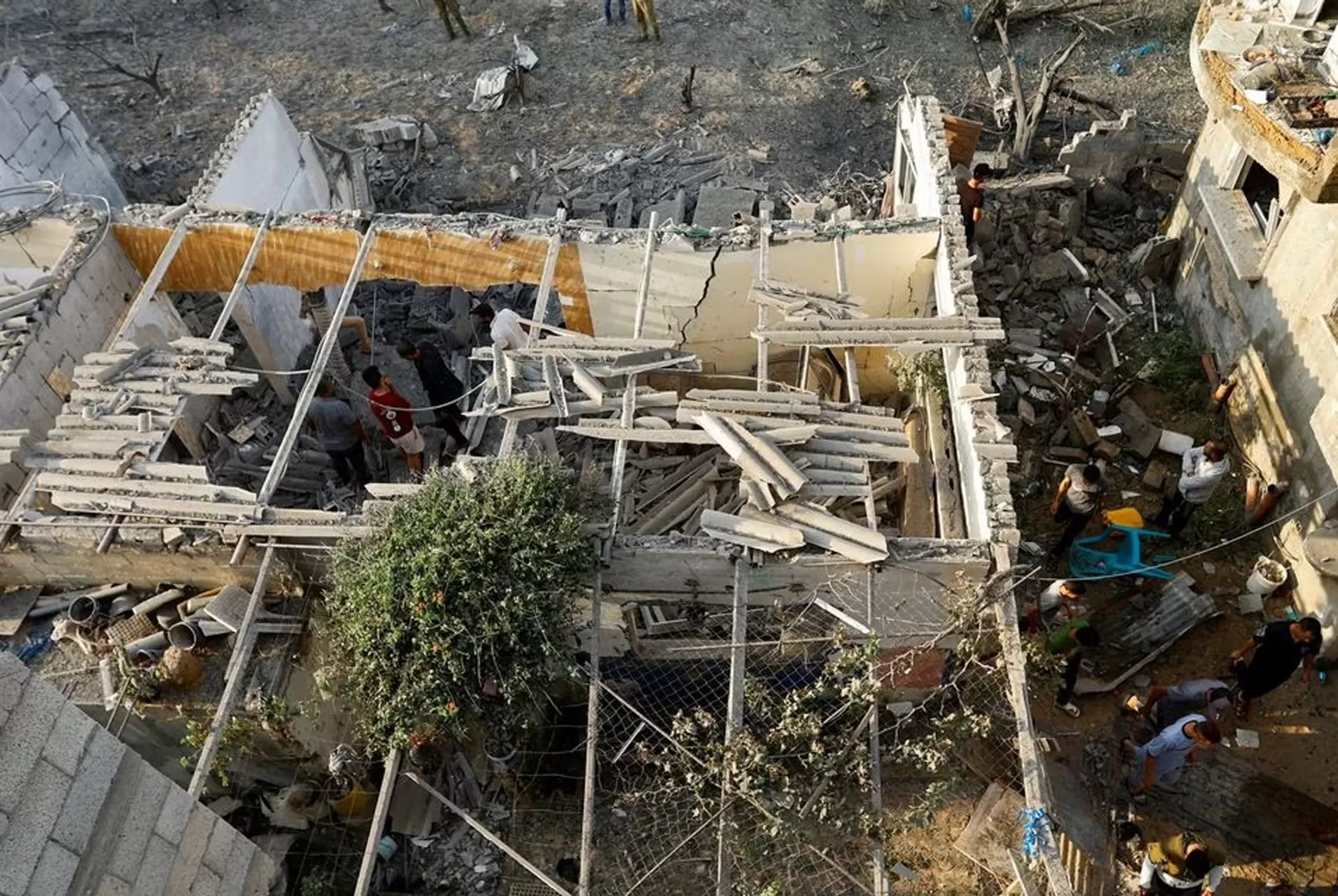 فلسطينيون يتفقدون الأضرار التي لحقت بمنزل أصابته غارات إسرائيلية في خان يونس
