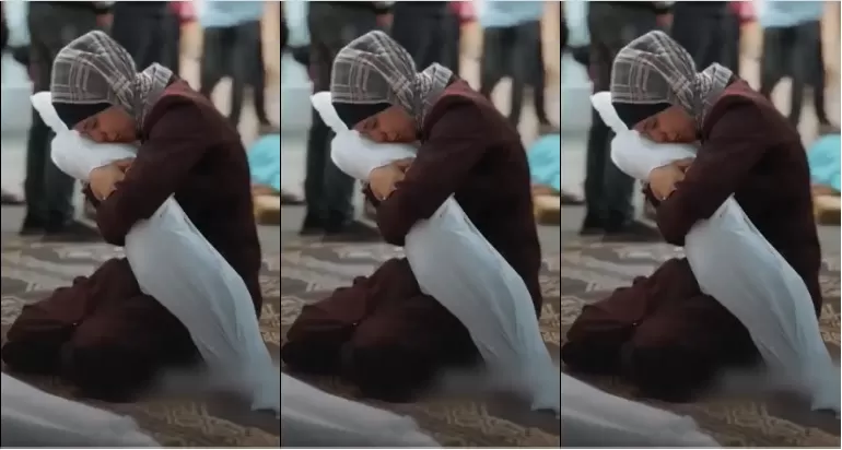 أم فلسطينية وهي تقبل جثمان طفلها بعد استشهاده في غارة للاحتلال