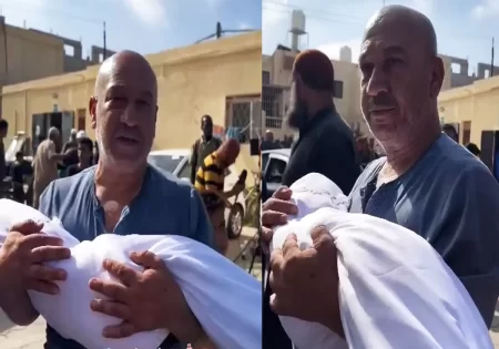 رجل فلسطيني وجثمان طفله الشهيد في غزة