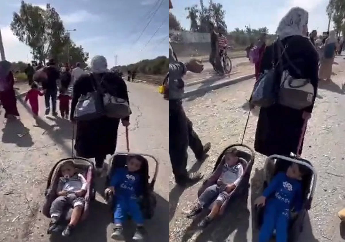 سيدة فلسطينية تجر طفليها عن مكان أمن بفعل الحرب في غزة