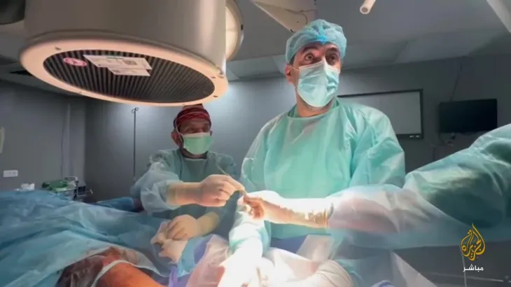 الدكتور محمد عبيد برفقة طبيبين آخرين أثناء إجراء عملية جراحية