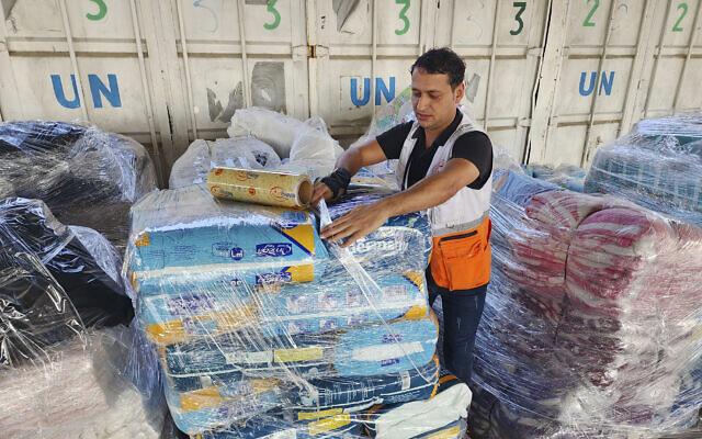 عامل يقوم بإعداد المساعدات لتوزيعها على الفلسطينيين في مستودع الأونروا في غزة
