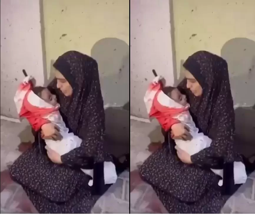 أم فلسطينية تحمل جثمان طفلها الشهيد