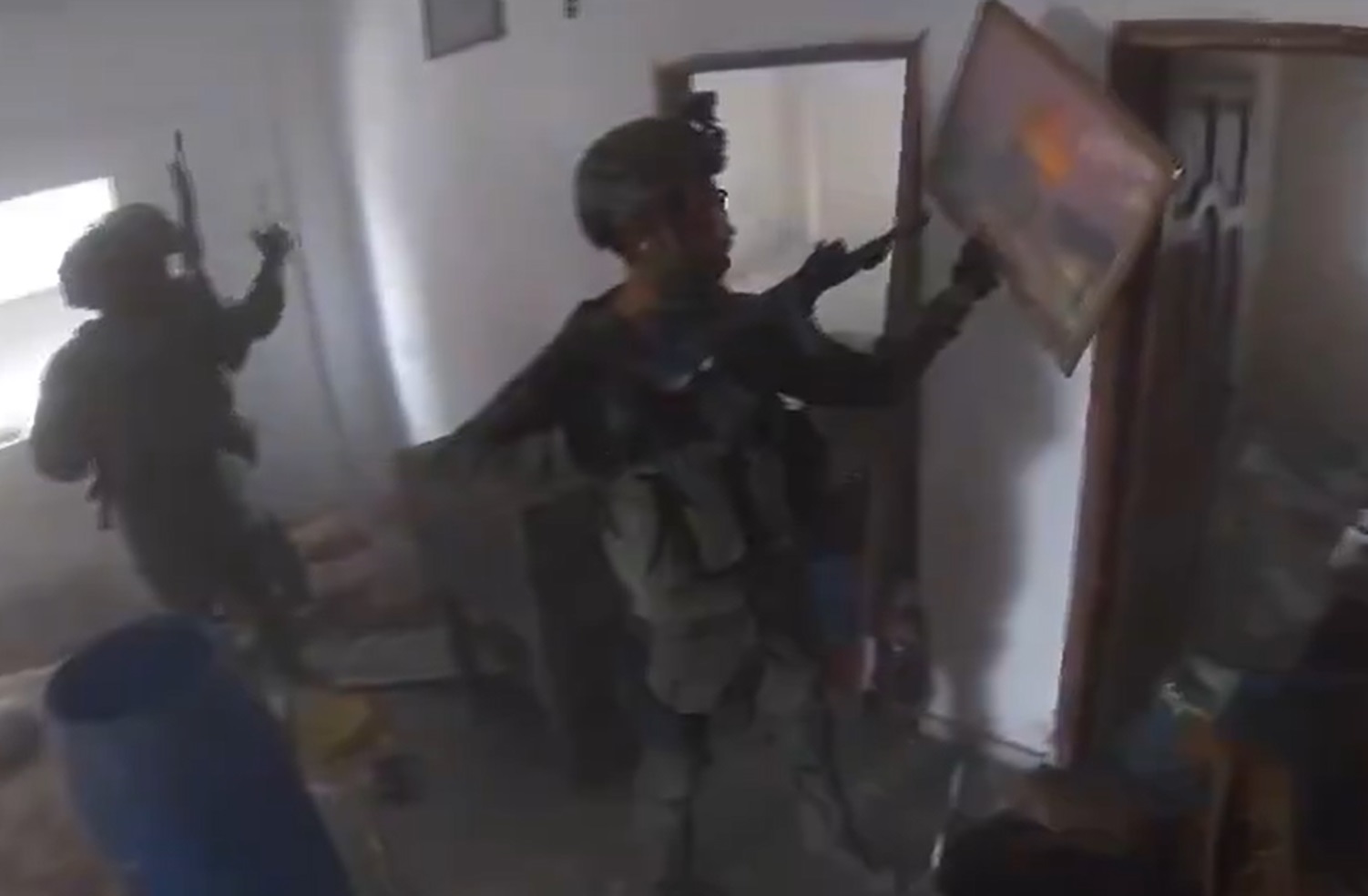 ضابط إسرائيلي يحطم صورة للمسجد الأقصى في أحد منازل غزة