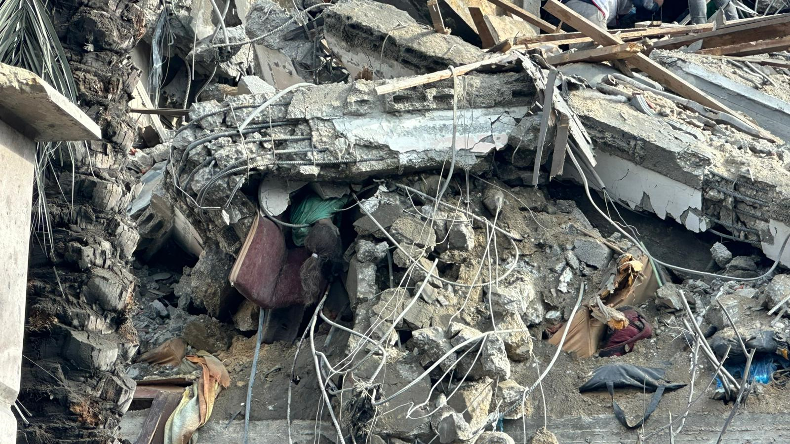 جثة طفلة شهيدة تتدلى من الأنقاض جراء مجزرة ارتكبها الاحتلال الإسرائيلي في جباليا