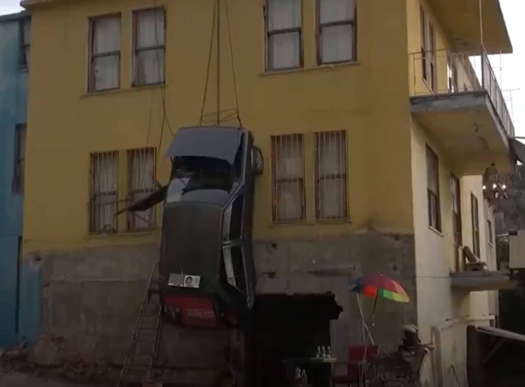 تركي يقوم بتعليق سيارته على سطح بنائه