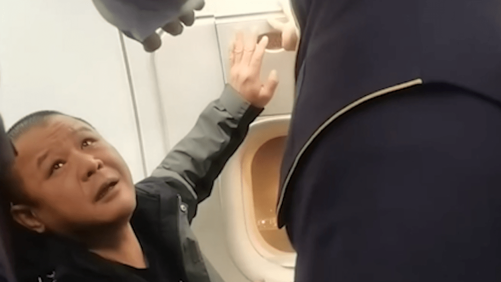 مسافر مخمور يحاول فتح باب الطائرة